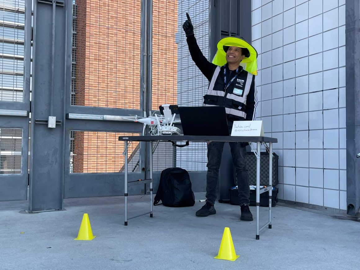 Eric Ruiz standing behind a table with a drone and laptop on it