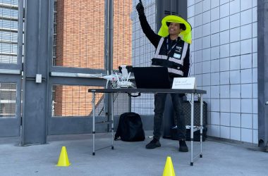 Eric Ruiz standing behind a table with a drone and laptop on it