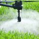 Spray drone releasing chemicals on crops or grass