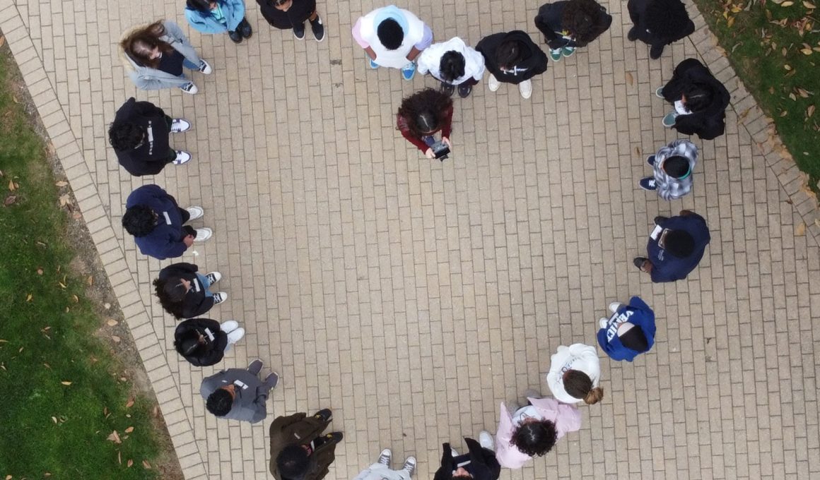 Young girls form a heart; image taken by a drone from an aerial view.