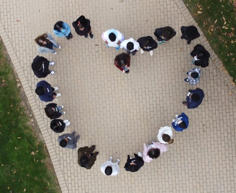 Young girls form a heart; image taken by a drone from an aerial view.