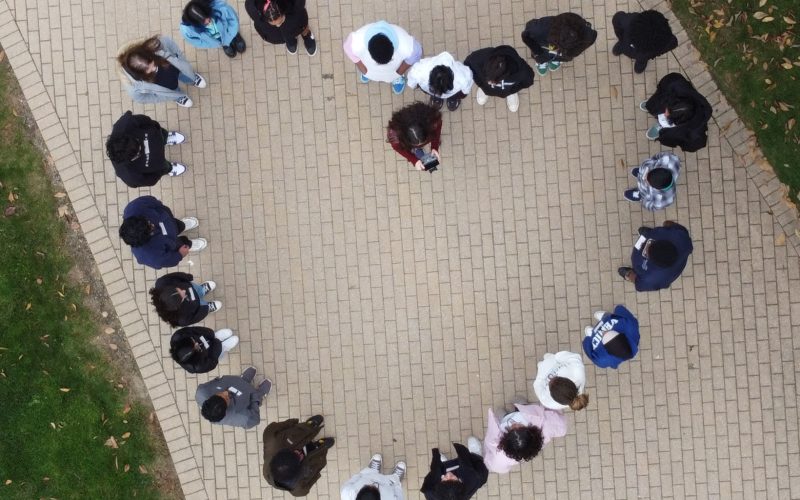 Young girls form a heart; image taken by a drone from an aerial view.