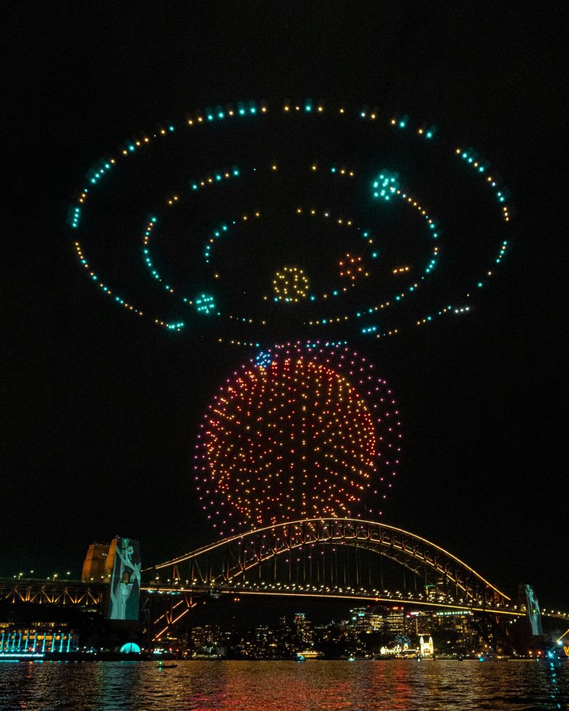 Drone light show over a city bridge